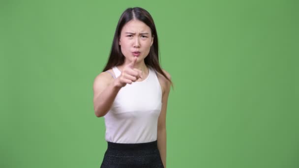 Young angry Asian businesswoman talking to camera — Stock Video