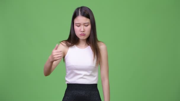 Young tired Asian businesswoman giving thumbs up — Stock Video