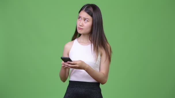 Молода приваблива азіатська комерсантка користується телефоном. — стокове відео