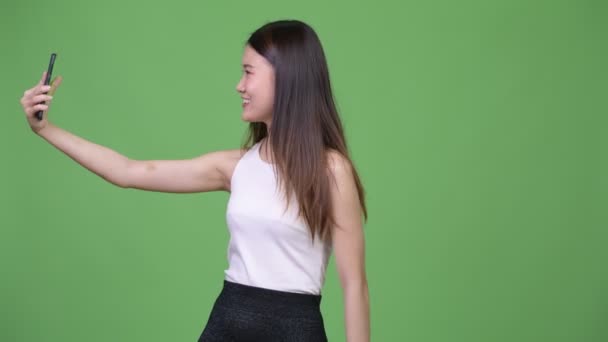 Young beautiful Asian businesswoman showing phone — Stock Video