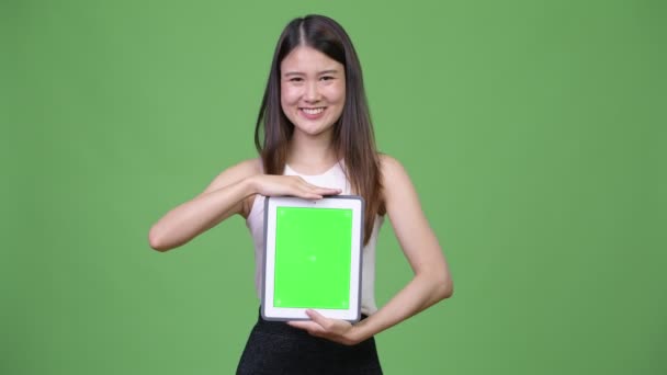 Молодая красивая азиатская бизнесвумен показывает цифровой планшет — стоковое видео