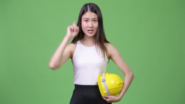 Jonge mooie Aziatische zakenvrouw als ingenieur die omhoog wijst — Stockvideo