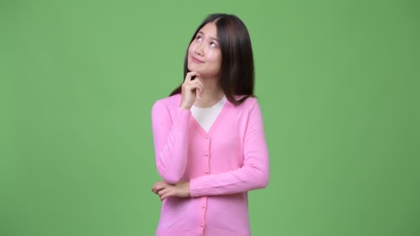 Young beautiful Asian woman thinking — Stock Video