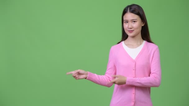 Jonge mooie Aziatische vrouw iets weergegeven: — Stockvideo