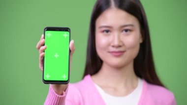 Genç güzel Asyalı kadın gösteren telefon
