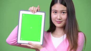 Genç güzel Asyalı kadın gösteren dijital tablet