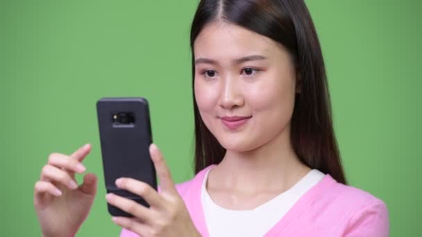 Молодая красивая азиатка по телефону — стоковое видео