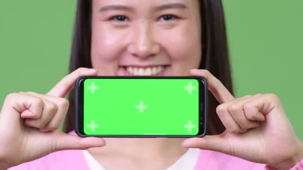 Молодая красивая азиатка показывает телефон — стоковое видео