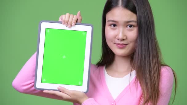 젊은 아름 다운 아시아 여 자가 보여주는 디지털 태블릿 — 비디오