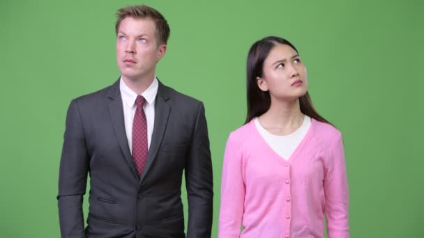 Young Asian woman and young businessman thinking together — Stock Video