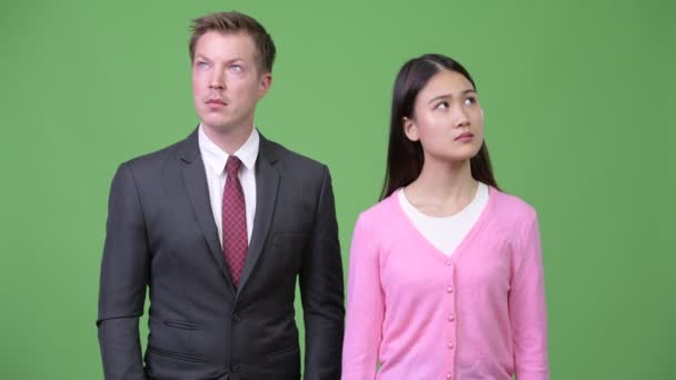 Młoda kobieta azjatyckich i młody biznesmen myślenia razem — Wideo stockowe