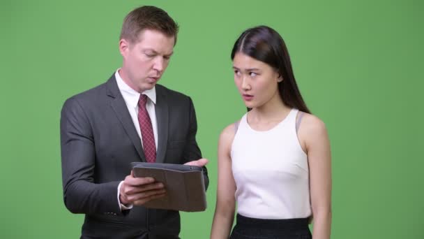 Ung affärsman visar dåliga nyheter till unga asiatiska affärskvinna — Stockvideo