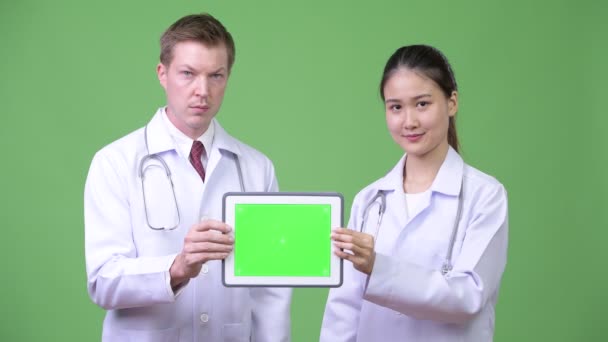 Multi-etnico coppia medici che mostrano tablet digitale insieme — Video Stock