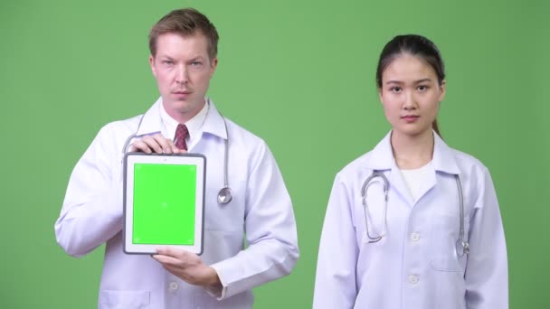 Multi-étnicos médicos pareja mostrando tableta digital juntos — Vídeos de Stock