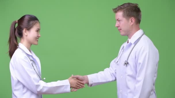 Multi-ethnic couple doctors shaking hands together — Stock Video