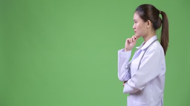 Perfil vista de joven feliz hermosa mujer asiática médico pensando — Vídeo de stock