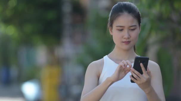 Jovem feliz bela mulher de negócios asiática usando telefone ao ar livre — Vídeo de Stock