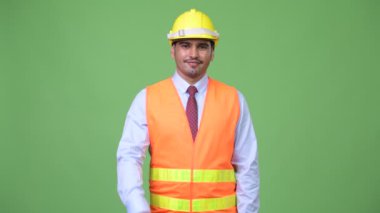 Genç yakışıklı Farsça adam inşaat işçisi kamera işaret