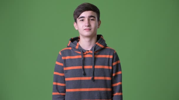 Młody przystojny irański nastoletnim chłopcem na zielonym tle — Wideo stockowe