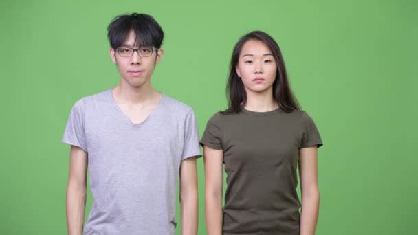 Unga lyckliga asiatiska paret tillsammans med armarna korsade — Stockvideo