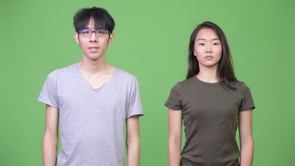 Молодая азиатская пара указывает вверх — стоковое видео