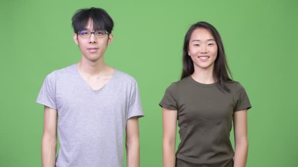 Joven pareja asiática apuntando hacia arriba — Vídeo de stock