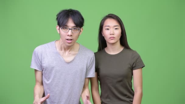 Joven pareja asiática buscando sorprendido juntos — Vídeo de stock