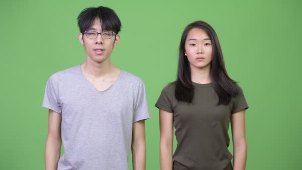 Молодая азиатская пара с пальцем на губах вместе — стоковое видео