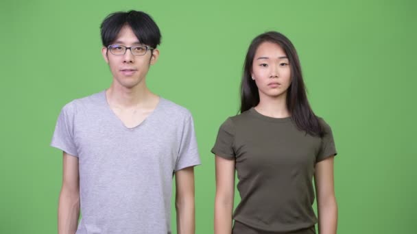 Joven pareja asiática dando pulgares abajo juntos — Vídeo de stock