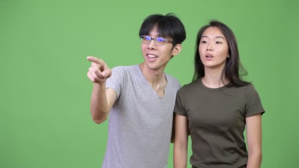 Mladý asijský pár hledá na stranu spolu — Stock video