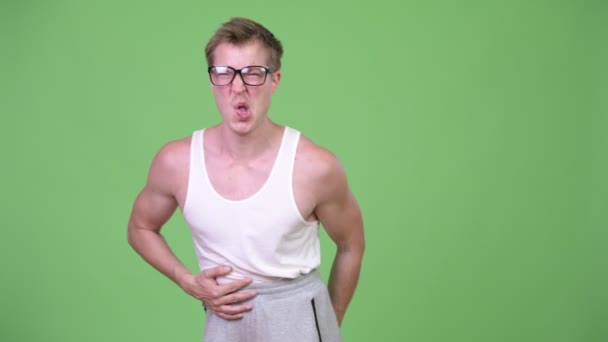 Νέοι nerd όμορφος άνθρωπος έχοντας πόνος στο στομάχι — Αρχείο Βίντεο