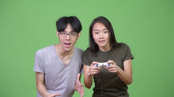 Jovem casal asiático jogando jogos juntos — Vídeo de Stock