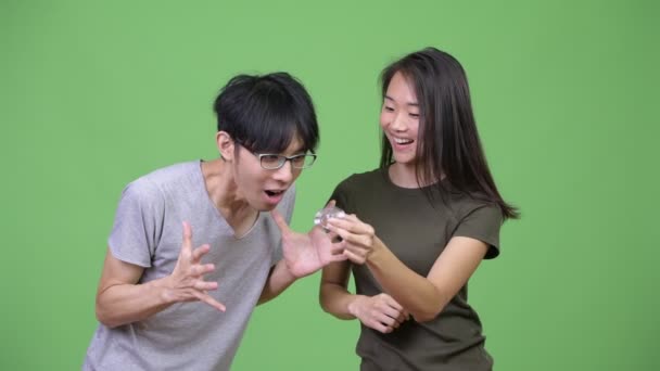 Mladý asijský pár si hraje s neposeda číselník dohromady — Stock video