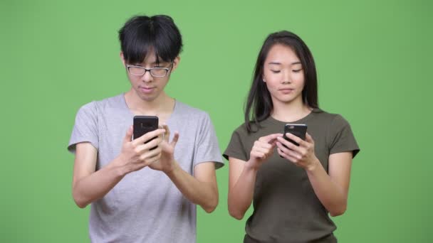 Jovem casal asiático usando telefone juntos — Vídeo de Stock