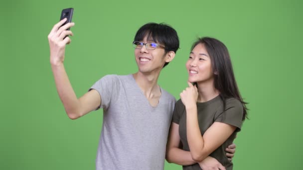 Joven pareja asiática usando teléfono juntos — Vídeo de stock