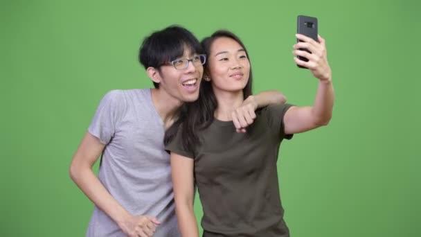 Молодая азиатская пара использует телефон вместе — стоковое видео