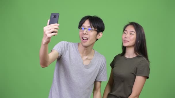 Young Asian couple showing phone together — Stock Video