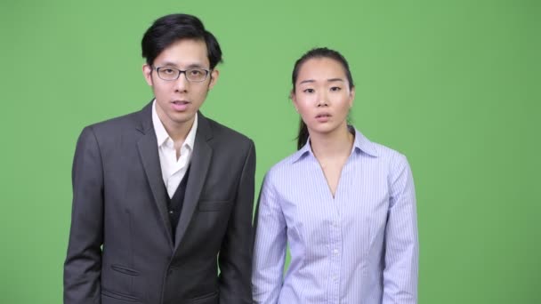 Молодая азиатская пара выглядит потрясенной вместе — стоковое видео