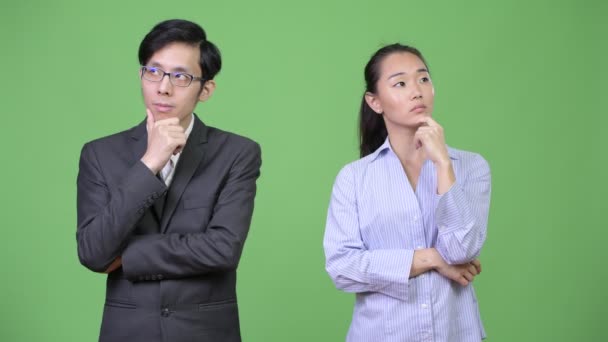 Young happy Asian business couple thinking together — Stock Video