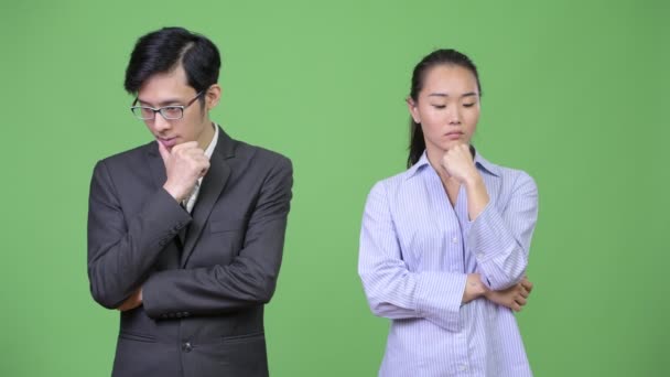 Jovem asiático casal de negócios pensando juntos — Vídeo de Stock