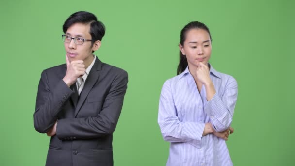 Jovem asiático casal de negócios pensando juntos — Vídeo de Stock