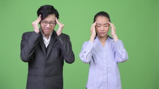 Jovem asiático casal de negócios tendo dor de cabeça juntos — Vídeo de Stock