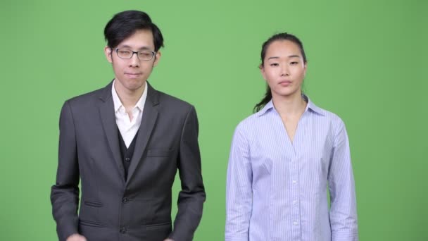 Jeune asiatique couple d'affaires haussant les épaules ensemble — Video