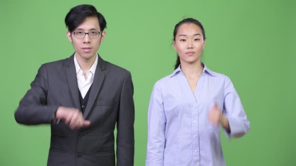 一緒にさまざまな意思決定を持っている若いアジア ビジネス カップル — ストック動画
