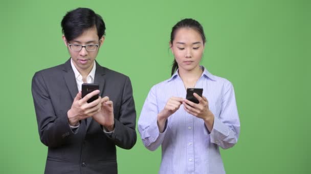 Genç Asya iş çift telefon birlikte kullanma — Stok video