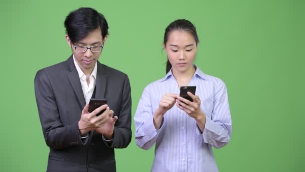 Jovem asiático casal de negócios usando telefone juntos — Vídeo de Stock