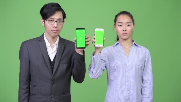 Giovane asiatico business coppia mostrando telefono insieme — Video Stock