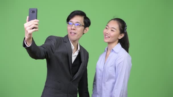 Mladá Asijská obchodní pár zobrazeno telefon dohromady — Stock video