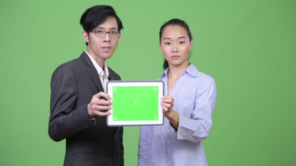 Jeune couple d'affaires asiatique montrant tablette numérique ensemble — Video