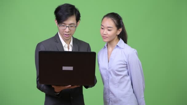 Young Asian business couple using laptop together — Stock Video